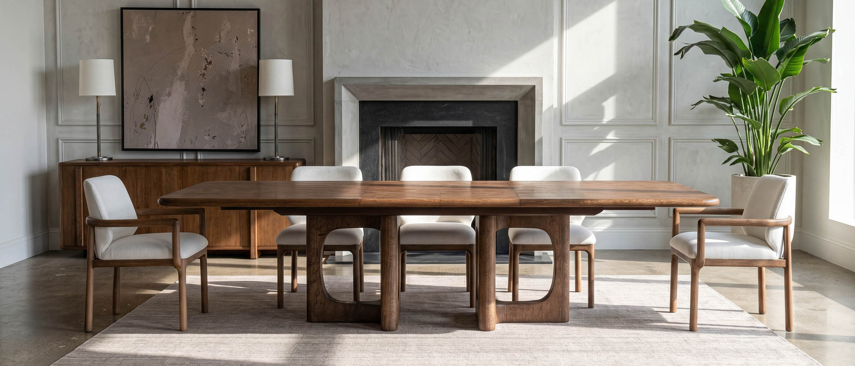 A Gramercy extension dining table set with upholstered chairs before a stone fireplace