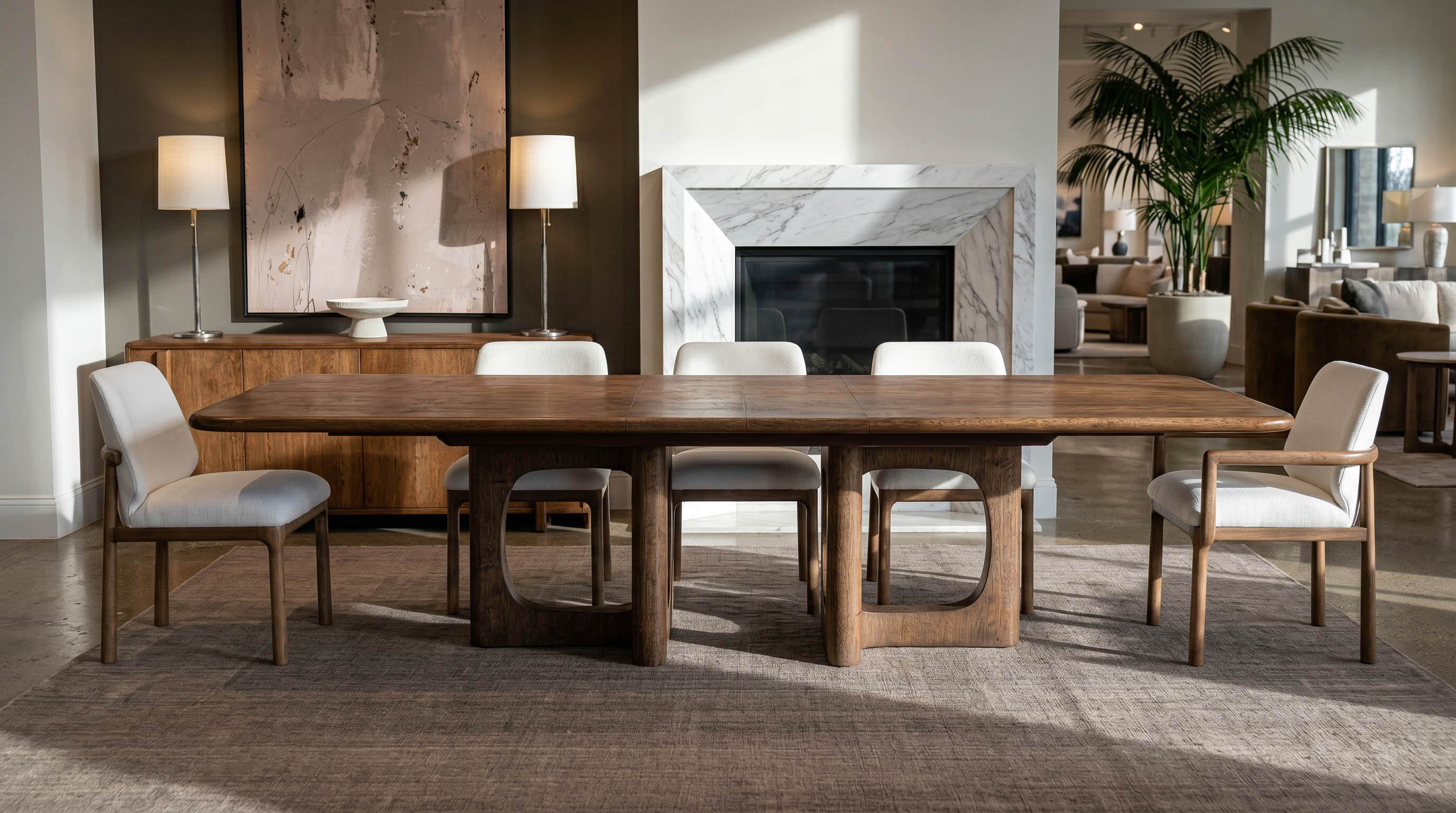 A walnut dining table on a sculptural base in a light-filled room